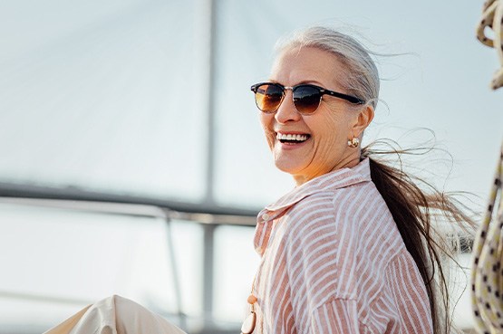 Woman in sunglasses smiling on boat