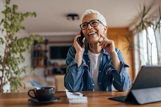 Woman smiling while talking on phone at home