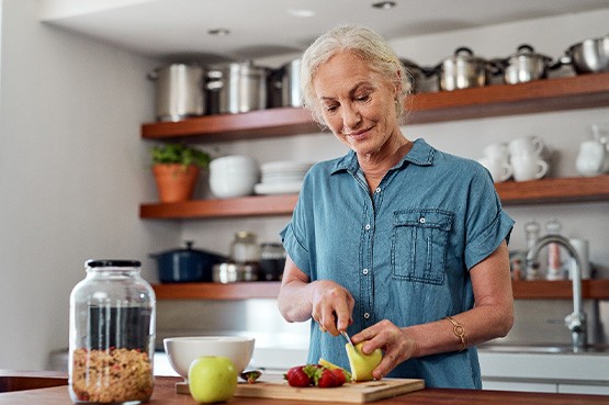 Woman smiling while preparing snack in kitchen