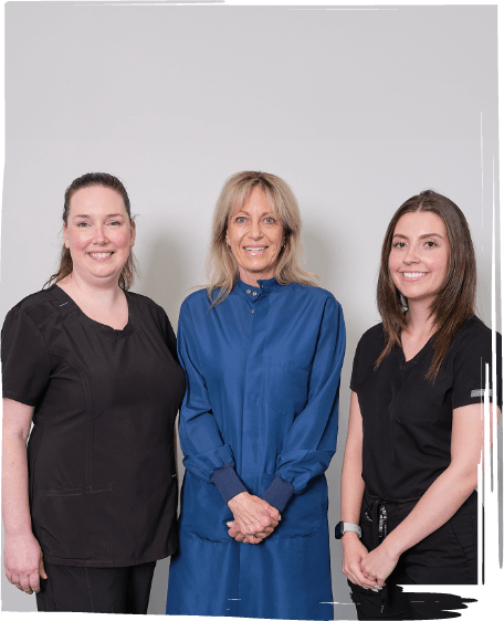 Three dentists laughing together in Worcester dental office