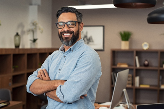 Man with glasses smiling in office