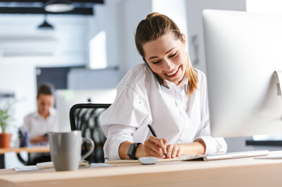 Woman talking on phone while taking notes