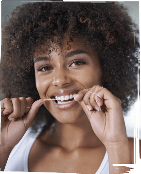 Woman smiling while flossing her teeth