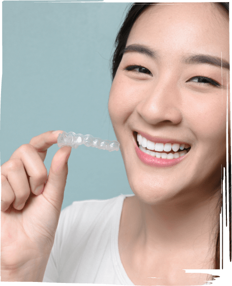 Smiling woman holding an Invisalign aligner