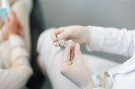 Dentist holding clear aligner