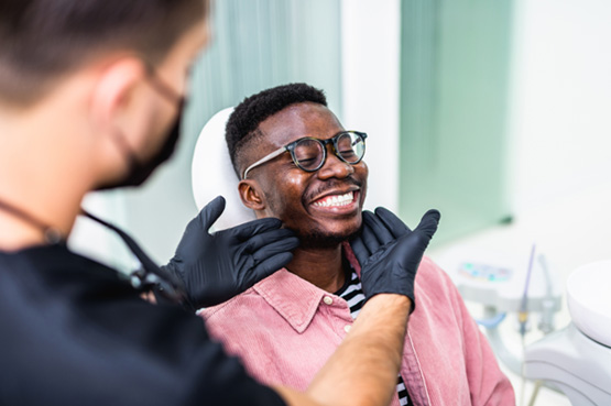 Dentist looking at patient's smile in treatment chair