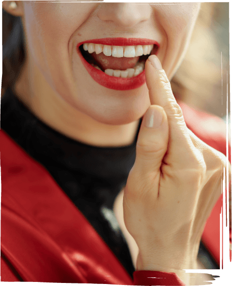 Woman with red lipstick looking at her teeth in mirror