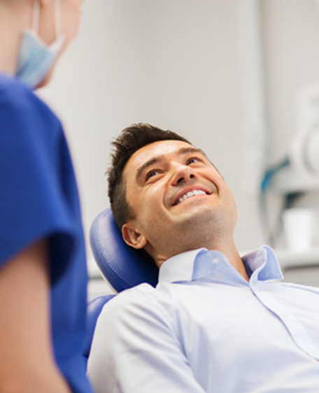 Man smiling at dental assistant in treatment room
